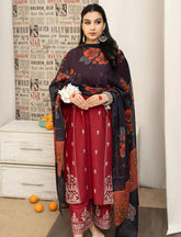 Woman in a traditional outfit with a dark dupatta and red dress, standing against a light-colored wall.